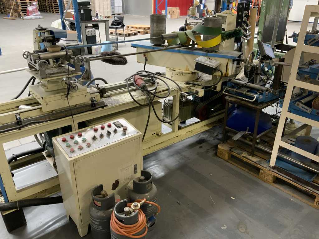 Tube machine including batch of tube rolls standing on approximately 25 pallets