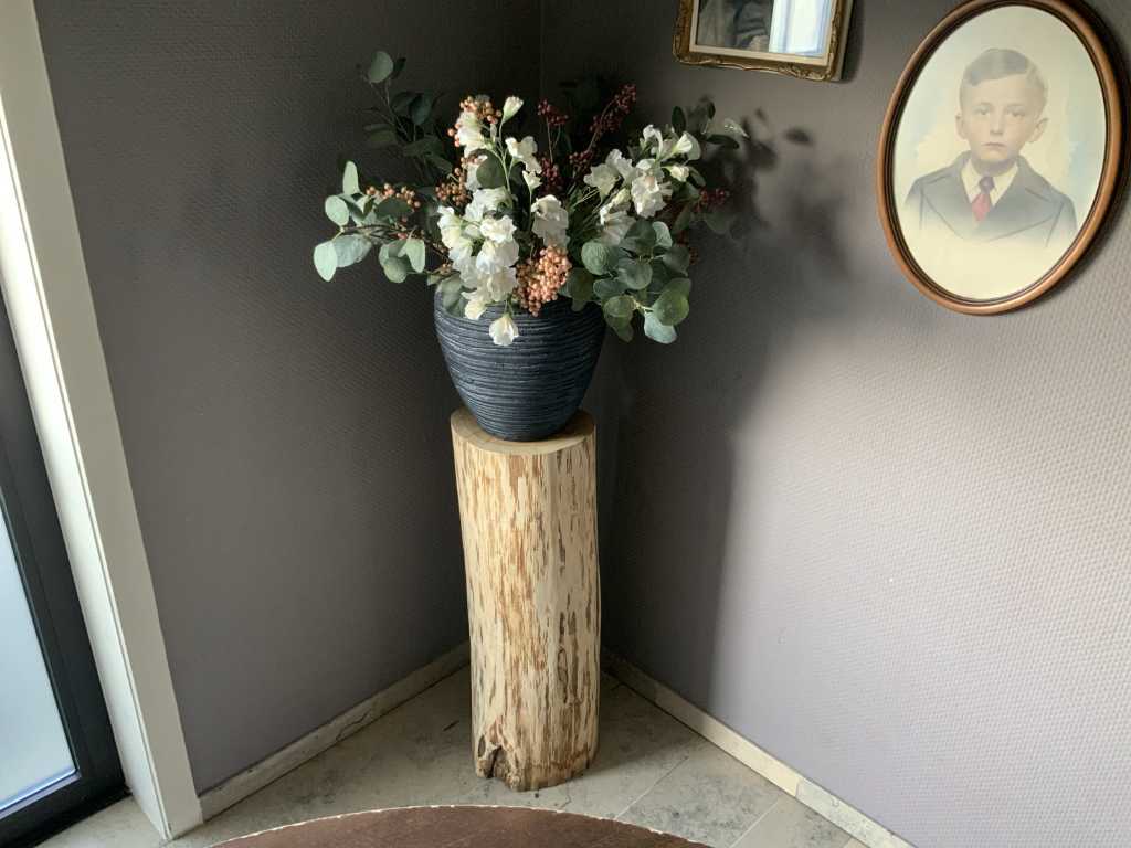 Blumentopf mit Kunstpflanze auf Holzsäule