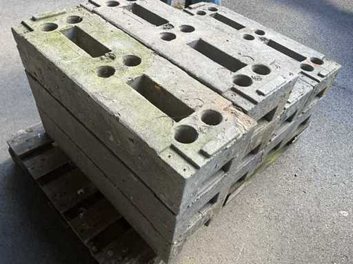 Dużo betonowych podstaw słupów / bloków postumentowych do ogrodzeń budowlanych Heras – ciężki beton