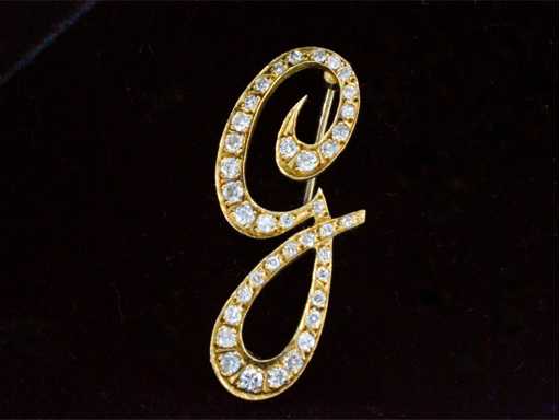 Geelgouden broche met diamant in letter G