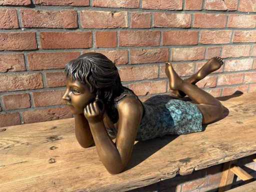 Scultura in bronzo della ragazza sdraiata