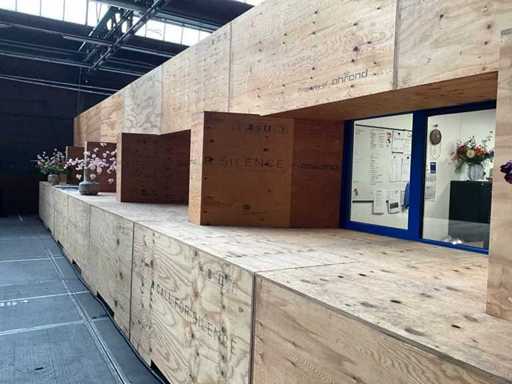 Dekorative Wand von etwa 16 Metern, bestehend aus Transportkisten und Unterlagenplatten